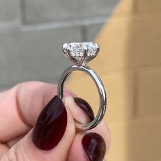 a person holding a ring with a diamond on it