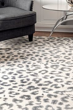 a living room area with a couch, chair and leopard print rug on the floor