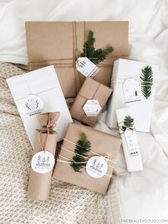 wrapped presents are tied with twine and decorated with evergreen branches, pine cones and white tags