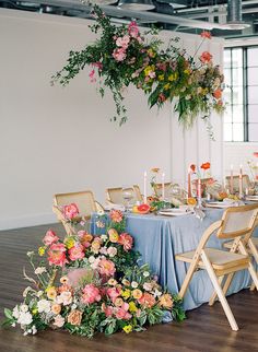 an arrangement of flowers and greenery decorates the centerpiece for a wedding reception