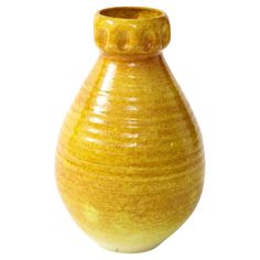 a yellow vase sitting on top of a white table