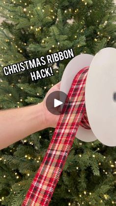 someone is holding a ribbon in front of a christmas tree with the words christmas ribbon hack