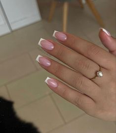 a woman's hand with pink and white manicured nails