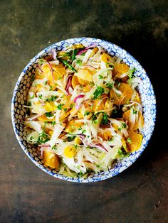 a blue and white bowl filled with food on top of a table