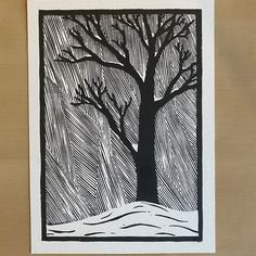 a black and white drawing of a tree with snow on the ground next to it