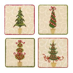 four cross stitch coasters decorated with christmas trees and candy canes on white background