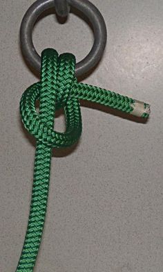 a green rope is attached to a metal hook