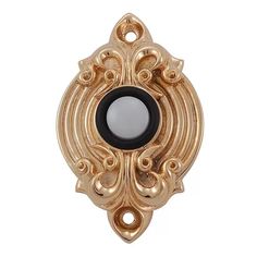 a gold and black broochle with an oval design on the center, surrounded by filigrees