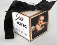 a baby's birth announcement box with a black ribbon tied around it and an image of a baby