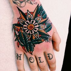 a person's hand with tattoos on it and the word hold written in black ink