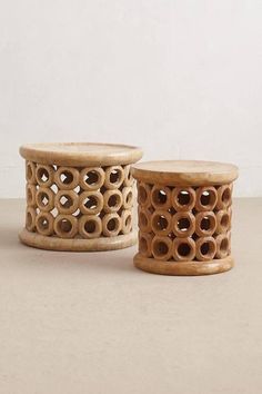 two wooden jars with holes in them sitting next to each other on a white surface