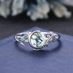 Accept engrave the words inside the ring service: https://www.etsy.com/listing/1103764936/engrave-service Engagement Ring: 5mm round cut natural moss agate. Side stone : lab created emerald Material Metal: 925 sterling silver, Solid 14k/18k gold,platinum This jewelry is made to order, it can be made with any gemstone/metals. 2-3 weeks to finish. Default Shipping method is usps. 30 days non-hassle return policy.For returned items,there may be handcrafting and shipping fee deducted. Note: All Prod Engraved Moonstone Round Ring For Weddings, Wedding Moonstone Ring Engraved Round Shape, Engraved Moonstone Wedding Ring, White Gold Cabochon Emerald Ring For Wedding, Nature-inspired Cabochon Ring For Anniversary, Wedding Engraved Moonstone Ring, White Gold Wedding Rings With Natural Inclusions, Engraved Moonstone Ring For Anniversary, Engraved Moonstone Anniversary Ring