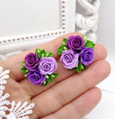 three purple roses are in the palm of someone's hand