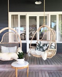 two wicker chairs sitting on top of a wooden floor next to a potted plant