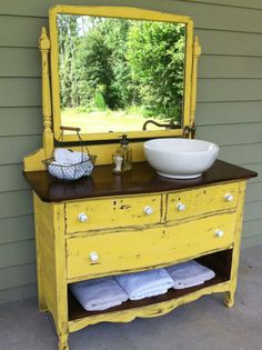 an old dresser turned into a vanity with a bowl on top and mirror above it