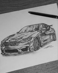 a drawing of a bmw car on paper with a pen next to it and a black marker