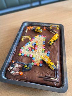 a chocolate cake with construction vehicles on it