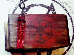 a wooden box with a red necklace hanging from it's side