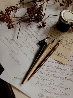 an old letter with writing on it next to a cup of coffee and some pens