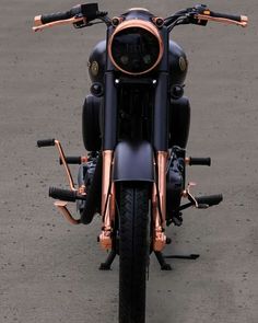 a black and gold motorcycle parked on top of a parking lot