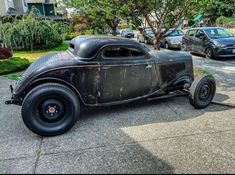 an old car is parked on the side of the road