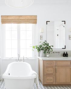 a white bath tub sitting under a bathroom mirror