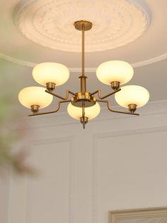 a chandelier hanging from the ceiling in a room with white walls and ceilings