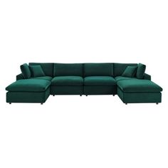 a green sectional couch with pillows on it