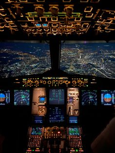 the cockpit of an airplane at night with multiple screens showing city lights and illuminated areas