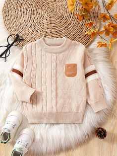 a sweater and sneakers on a white rug