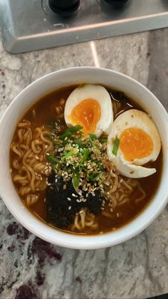 a bowl of ramen with two boiled eggs on top