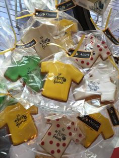 decorated cookies in the shape of shirts and t - shirts are on display for sale