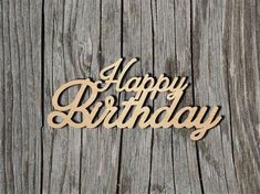 the word happy birthday is cut out of wood on a wooden surface with a string attached to it