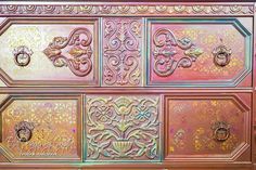 an old dresser with ornate designs painted on it