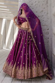 Midnight purple lehenga with gold dori and aari embroidered floral motifs. Paired with blouse and dupatta.
Components:3
Pattern:Embroidery
Type of Work:Dori, aari, floral
Neckline:V neck
Sleeve Length:Half
Fabric:Chiniya silk, organza
Color:Purple
Other Details:
Side tassel tie-up
Embroidered sheer dupatta
Note: Hair accessory worn by the model is not for sale
Occasion:Bride - Aza Fashions Purple And Gold Lehenga, Unstitched Purple Traditional Wear With Gota Work, Purple Traditional Wear With Dori Work, Traditional Purple Wear With Dori Work, Purple Banarasi Silk Set For Eid, Purple Banarasi Silk Sets With Zari Work, Unstitched Gold Lehenga With Meenakari Detail, Gold Lehenga With Meenakari In Traditional Drape, Unstitched Gold Lehenga With Meenakari