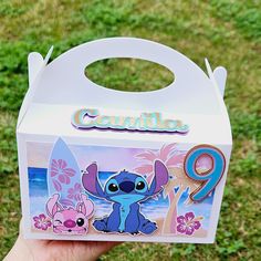 someone is holding up a box with the character lil from disney's stitchy friends