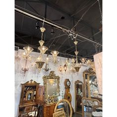 a room filled with lots of antique furniture and lights hanging from it's ceiling