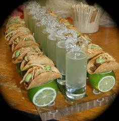 a wooden table topped with lots of food and drink glasses filled with drinks next to each other