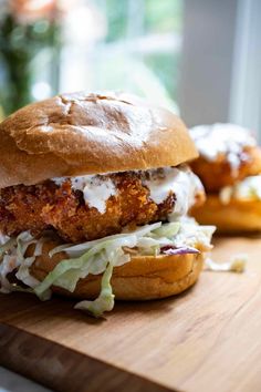 a chicken sandwich with cole slaw on a cutting board