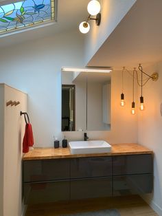 a bathroom with two sinks and a stained glass window in the ceiling over it's mirror