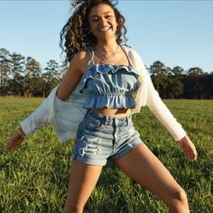 a young woman is posing in the grass