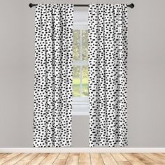 black and white polka dot curtains hanging on a window sill in a room with hardwood floors