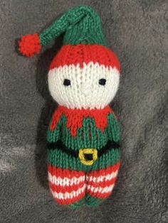 a knitted stuffed animal with a green and red hat on it's head