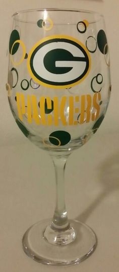 a green bay packers wine glass sitting on top of a table