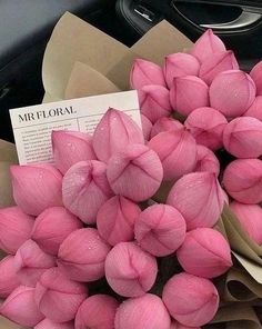 a bunch of pink flowers sitting on top of a table next to a black car