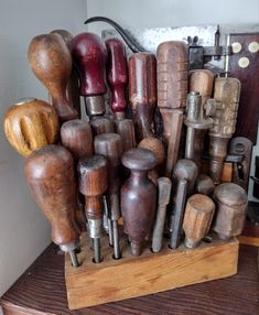 an assortment of woodworking tools are displayed on a wooden stand in front of a wall