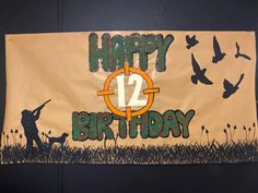 a happy 12th birthday banner hanging on the wall with birds flying in the air behind it