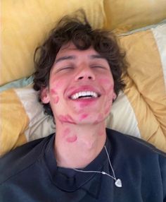 a man laying on top of a bed covered in pink and white stuff with his eyes closed