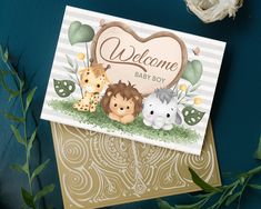 a welcome baby boy card with animals and a heart on it's back, sitting next to some flowers