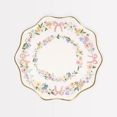 a white plate with floral designs and gold trimmings on the edge, in front of a white background